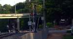 A family hustles across the Washington St. crossing as NS yard job E23 descends the Old Main Line hill with interchange traffic for CSX.